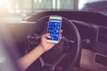 BANGKOK, THAILAND - NOVEMBER 12th, 2017 : Hand of woman using mobile phone with icons of social media on screen in the car Royalty Free Stock Photo