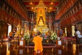 Bangkok, Thailand - November 11 2019: Unidentified Buddhist monk pays respect to the Buddha Sihing statue inside the Phutthai