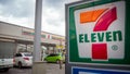 BANGKOK, THAILAND - October 15, 2023: Customers Shopping at 7-11 Store with Cars Parked in the Foreground