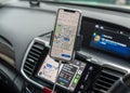 Google Maps app with Apple CarPlay on car screen dashboard and iPhone, smart UI mobile application for travel navigation