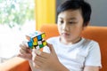 Bangkok, Thailand - October 1, 2019: Little boy play Rubik`s Cube. Rubik`s cube invented by a Hungarian architect Erno Rubik in Royalty Free Stock Photo