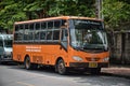 Old orange retro bus parking on the side of a quiet street of Bangkok