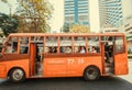 Passengers of public bus driving through street of urban city, with traffic of asian capital