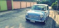 Blue/White classic Mini cooper car parked on the street with sunlight and copy space in vintage color style Royalty Free Stock Photo