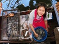 A girl grills seafood on the barbecue of her boat at the Taling Chan Floating Market in Bangkok