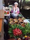 A girl prepares papaya salad in her boat at the Taling Chan Floating Market in Bangkok