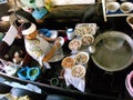 A man cooks in the typical kitchen on a boat at the Taling Chan Floating Market in Bangkok