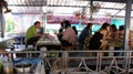 People tasting different dishes at the tables of the Taling Chan Floating Market in Bangkok