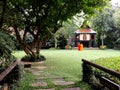 Two Buddhist monks gaze at an old traditional teak wood house in the gardens of the Suan Pakkad Palace Museum in Bangkok, Thailand