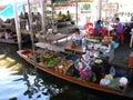 A woman cooks in her boat at the Taling Chan Floating Market in Bangkok