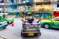 BANGKOK, THAILAND - 1.11.2019: Tuk tuk taxi rider is resting in the car with cigarette in his hand. TukTuk is famous taxi service Royalty Free Stock Photo