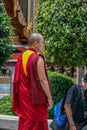 Young Buddhist monks as tourists walking around territory of Grand Palace. Ancient architecture of Asia.