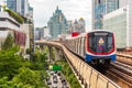 Bangkok: a train leaves Nana BTS station, with a view of modern downtown buildings and Sukhumvit Road