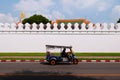 Bangkok Tuk Tuk taxi on street with white concrete wall of grand palace Royalty Free Stock Photo