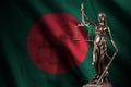 Bangladesh flag with statue of lady justice and judicial scales in dark room. Concept of judgement and punishment