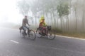 Bangladesh Ã¢â¬â January 06, 2014: On a foggy winter morning, two young boy and girl are going to school by riding bicycle. at