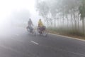 Bangladesh Ã¢â¬â January 06, 2014: On a foggy winter morning, two young boy and girl are going to school by riding bicycle. at