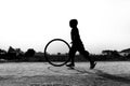 A restless boy is playing on the village road with old discarded tires at Savar, Dhaka,