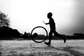 A restless boy is playing on the village road with old discarded tires at Savar, Dhaka,