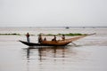 Some fishermen are catching fish with long fishnet from traditional fish-boat in the Meghna river at