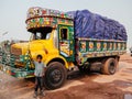 Bangladesh kid and colourful freight carrier truck on dirt road of Dhaka city