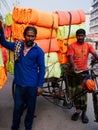 Bangladesh people carrying a lot of colourful fabric rolls on small bicycle on street of Dhaka city