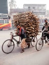 Bangladesh people carrying a lot of wood on small bicycle on street of Dhaka city