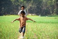 Bangladeshi agricultural fields. Two children are dancing happily on the path. Village: Puijor, City: Rajbari, Bangladesh. Capture