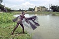 Bangladeshi Fisherman throwing fishing net in a lake