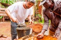 Bangoua, Cameroon - 08 august 2018: young european man in african village doing manual work building water well with concrete in