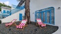 Two lawn chairs are peacefully resting next to a tree, creating a serene spot for relaxation and enjoying nature Royalty Free Stock Photo