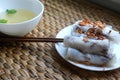 Banh cuon-vietnamese steamed rice rolls with minced meat inside accompanied by bowl of fish sauce.