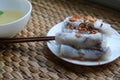 Banh cuon-vietnamese steamed rice rolls with minced meat inside accompanied by bowl of fish sauce.