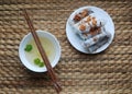 Banh cuon-vietnamese steamed rice rolls with minced meat inside accompanied by bowl of fish sauce.