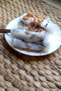 Banh cuon-vietnamese steamed rice rolls with minced meat inside accompanied by bowl of fish sauce.