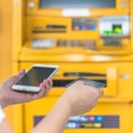 Bank ATM Auto Teller Machine with customer user person using credit card, or debit card and smartphone for paying cash payment Royalty Free Stock Photo