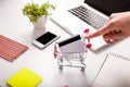 Bank card nearby a laptop and mini shopping cart Royalty Free Stock Photo