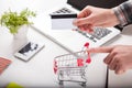 Bank card nearby a laptop and mini shopping cart Royalty Free Stock Photo