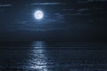 A Bank Of Clouds Separates This Bright Full Moon from the Quiet Ocean Below Royalty Free Stock Photo