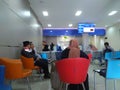 Bank customers sitting, waiting for financial transactions at Bank Dinar, an Islamic financial institution in Indonesia