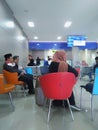 Bank customers sitting, waiting for financial transactions at Bank Dinar..