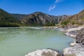 The bank of the Katun river with water containing turquoise clay and a sandy beach, rocky coast against the backdrop of mountains Royalty Free Stock Photo