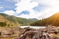 The bank of the Katun river with water containing turquoise clay and a sandy beach, rocky coast against the backdrop of mountains Royalty Free Stock Photo