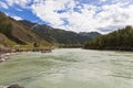 The bank of the Katun river with water containing turquoise clay and a sandy beach, rocky coast against the backdrop of mountains Royalty Free Stock Photo