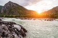 The bank of the Katun river with water containing turquoise clay and a sandy beach, rocky coast against the backdrop of mountains Royalty Free Stock Photo