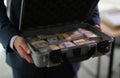 Banker holding suitcase with many dollar bills closeup