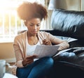 Banking, paperwork and black woman in home with bills, document and reading investment report. Wealth, savings or person Royalty Free Stock Photo
