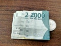 The banknote IDR 2,050 Is displaying on the middle of brown table texture Royalty Free Stock Photo
