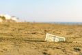 Banknote of value of one dollar in the the sand on the beach. Concept of cheap travel and vacation.