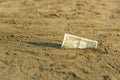 Banknote of value of one dollar in the the sand on the beach. Concept of cheap travel and vacation. Royalty Free Stock Photo